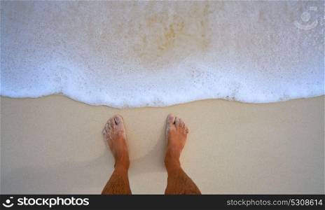 Tourist man feet in tropical white sand beach vacation concept