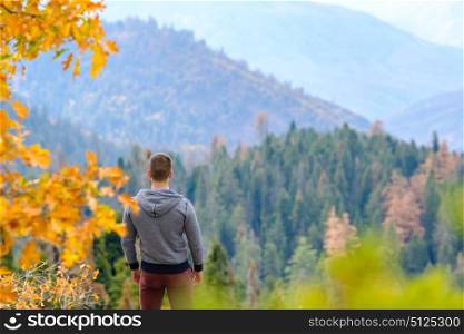 Tourist man hiking in Sequoia National Park at fall, looking at autumn mountain scenic landscape. California, United States.