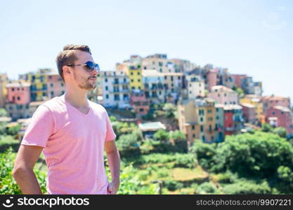 Tourist man with amazing scenic view of old village in Cinque Terre, Liguria, Italy. Tourist looking at scenic view of Manarola, Cinque Terre, Liguria, Italy