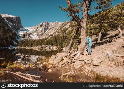 Tourist near Dream Lake in Colorado. Woman tourist near Dream Lake at autumn in Rocky Mountain National Park. Colorado, USA.