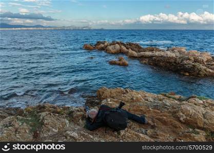Tourist on a cliff photographing the sea, Provence, Cote d&rsquo;Azur, France