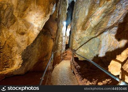 Tourist path in a beautiful old dark cave with many stalactites. Grotte di Is Zuddas, Italy, Sardinia