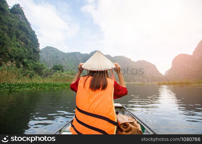 tourist sitting on boat for travel around Tam Coc beatiful nature river and mountain, Tam Coc Ninh Binh, Vietnam. subject is blurred.