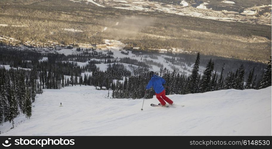 Tourist skiing in valley, Kicking Horse Mountain Resort, Golden, British Columbia, Canada