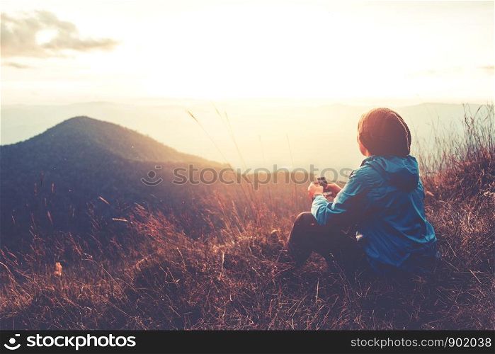 Tourist trail hiking in the forest Traveler man Relax , Looking Sunset on the mountain Traveler concept
