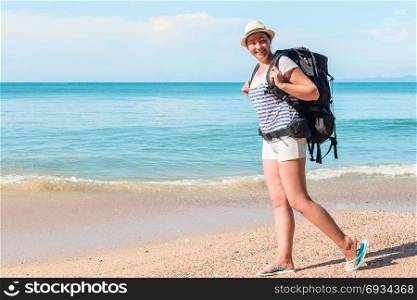 tourist with a backpack walks along the sandy beach of the resort of Thailand on a sunny day
