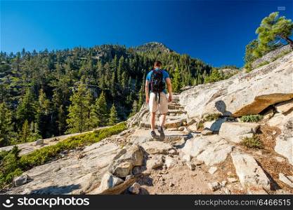 Tourist with backpack hiking in mountains at Lake Tahoe in California, USA