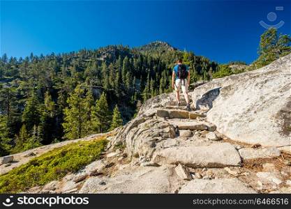 Tourist with backpack hiking in mountains at Lake Tahoe in California, USA