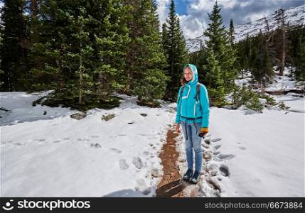 Tourist with backpack hiking on snowy trail. Tourist with backpack hiking on snowy trail in Rocky Mountain National Park, Colorado, USA.