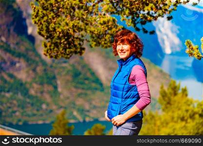 Tourist woman on the mountain top looking at view of fjord mountains, Norway. National tourist scenic route Aurlandsfjellet. Holidays relaxation on trip.. Tourist on mountains top, Norway