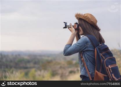 tourist woman taking a photo with her camera in nature