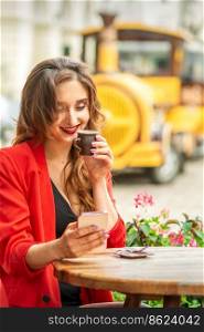 Tourist young caucasian woman in red jacket with coffee cup at the table in cafe outdoors. Tourist young caucasian woman in red jacket with coffee cup at the table in cafe outdoors.