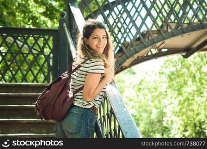 Tourist young woman on the bridge in a beautiful park.
