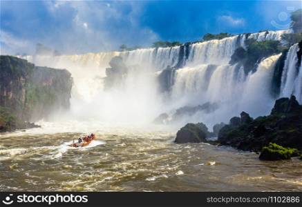 Touristic boat heading towards the powerfull stream of Iguazy Falls panorama, Puerto Iguazu Argentina