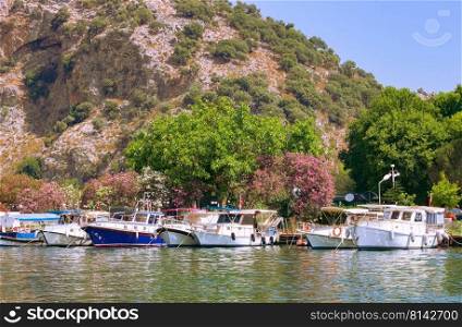 Touristic River Boats moored at the pier of the Dalyan River, Mugla, Turkey. Travel destination, summer photo.. Touristic River Boats moored at the pier of the Dalyan River, Mugla, Turkey.