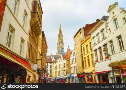 Touristic shopping street with cafes and restaurants, The Collegiate Church of Saints Peter and Guy view in background, Brussels, Belgium