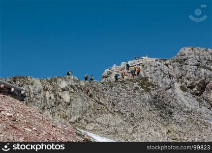 Tourists and Climbers Walking in Stone Path among Barren Mountains in Italian Dolomites Alps in Summer Time