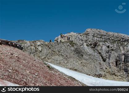 Tourists and Climbers Walking in Stone Path among Barren Mountains in Italian Dolomites Alps in Summer Time