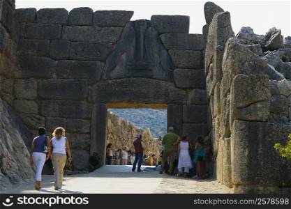 Tourists at an old ruin, Lion Gate, Mycenae, Peloponnese, Athens, Greece