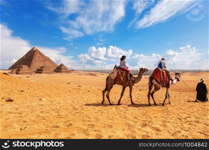 Tourists, camels, bedouins and the Pyramids in Giza desert.. Tourists, camels, bedouins and the Pyramids in Giza desert