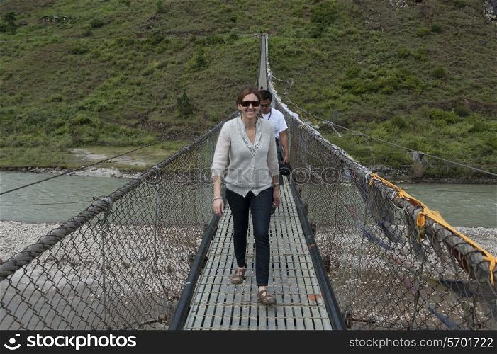 Tourists crossing the bridge across Puna Tsang River, Punakha District, Bhutan