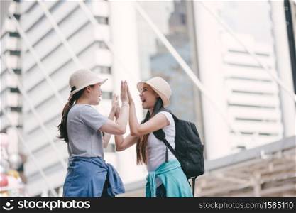 Tourists Doing High Five While Standing In City