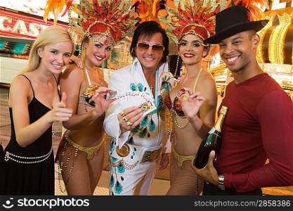 Tourists, Elvis impersonator and female dancers having fun
