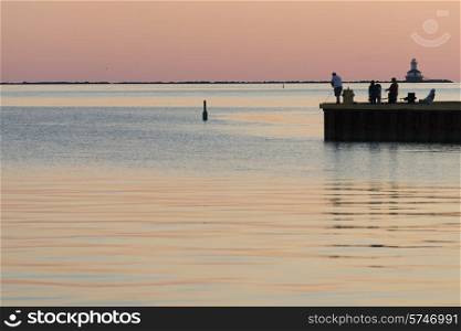Tourists fly-fishing on pier at sunset, Spinnakers Landing, Summerside, Prince Edward Island, Canada