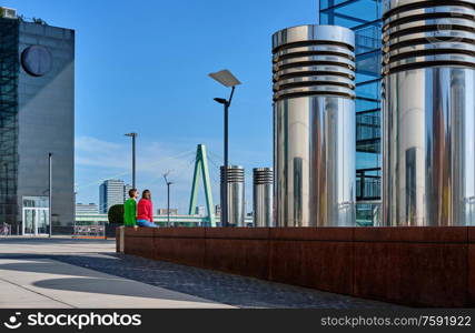 Tourists in Cologne near Kranhaus building complex with crane house on riverside of Rhein in Cologne, Germany.