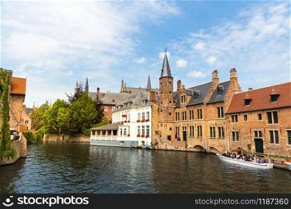 Tourists in walking boat on river canal in old tourist town, Europe. Ancient european city, famous place for travel and tourism, traditional architecture
