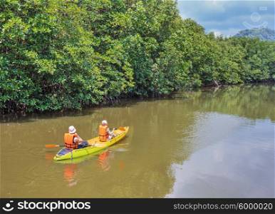 Tourists kayaking floating on the river in the jungles of Thailand