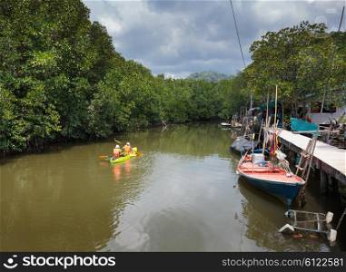 Tourists kayaking floating on the river in the jungles of Thailand