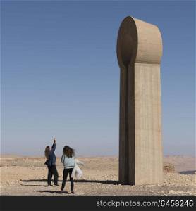 Tourists near sculpture in Sculpture Garden, Makhtesh Ramon, Negev Desert, Israel