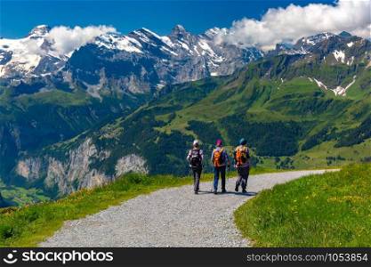 Tourists on hiking trail on mountain Mannlichen, popular viewpoint in Swiss Alps, Switzerland.. Mountain Mannlichen, Switzerland