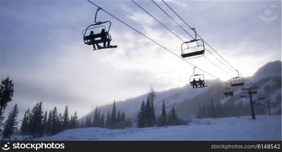 Tourists on ski lifts in valley, Kicking Horse Mountain Resort, Golden, British Columbia, Canada