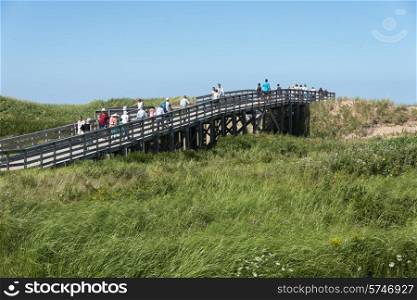 Tourists on wooden bridge at Cavendish Beach, Green Gables, Prince Edward Island, Canada
