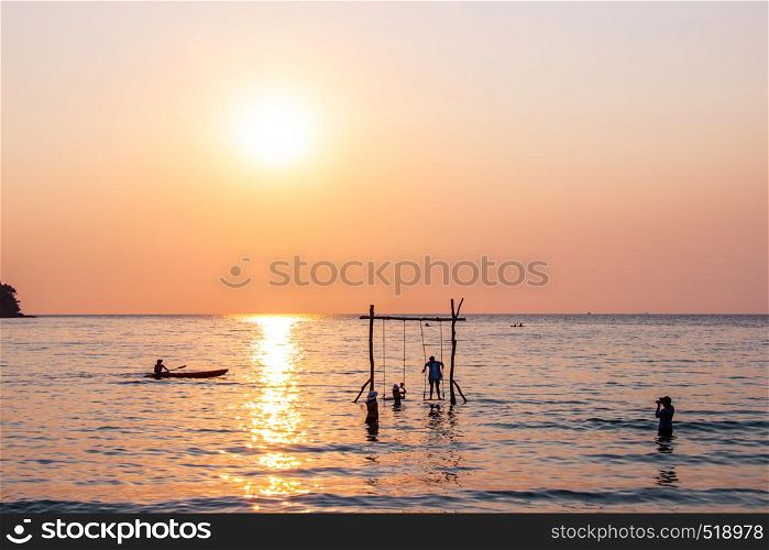 Tourists play in the water sea during the sunset at area ao bang bao Koh kood island Trat, Thailand.