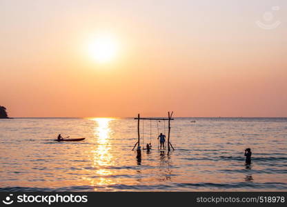 Tourists play in the water sea during the sunset at area ao bang bao Koh kood island Trat, Thailand.