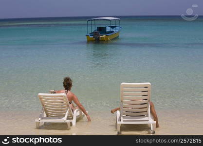 Tourists sitting on the beach chairs, West Bay Beach, Roatan, Bay Islands, Honduras