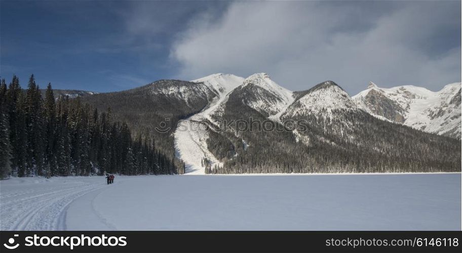 Tourists skiing in snow covered valley, Emerald Lake, Field, British Columbia, Canada