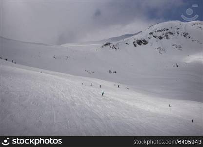 Tourists snowboarding and skiing on snow covered mountain, Whistler, British Columbia, Canada