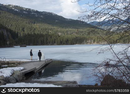 Tourists standing on a dock at the lakeside, Whistler, British Columbia, Canada