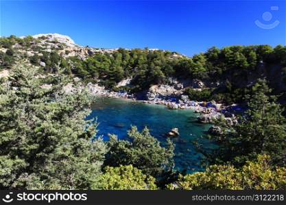 Tourists swim and play in Crystal clear waters at Anthony Quinn Bay in Greece