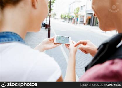 Tourists using navigation app on the mobile phone.. Looking for their destibation