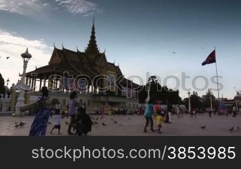 Tourists walk in the square in front of the Royal Palace, Phnom Penh, Cambodia. Time lapse