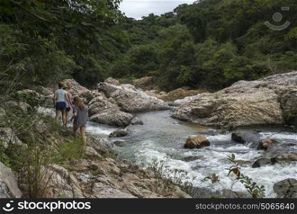 Tourists walking along river in forest, Yelapa, Jalisco, Mexico