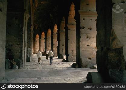 Tourists walking inside a coliseum, Rome, Italy