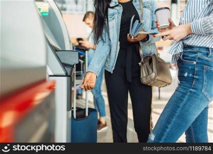 Tourists with luggage withdraw cash at ATM in airport. Passengers with baggage in air terminal, happy journey, summer travel on vacation