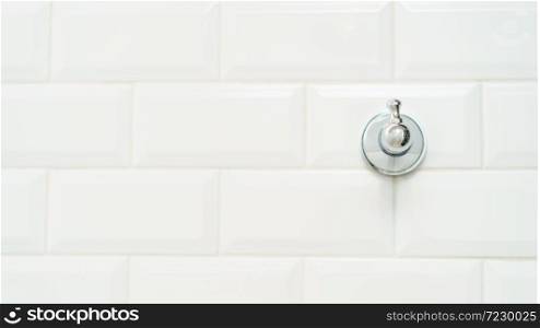 Towel metal hook on the white brick wall.