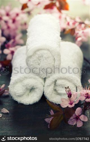 towels and spring cherry blossoms on wooden table